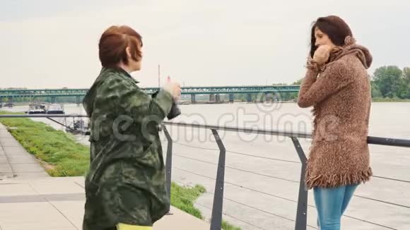 美丽的黑发女人摆在女人面前的镜头视频的预览图
