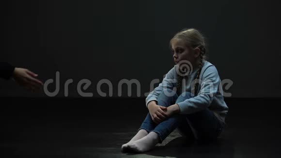 不信任的小女孩坐在黑暗的房间里拒绝成人的帮助害怕视频的预览图