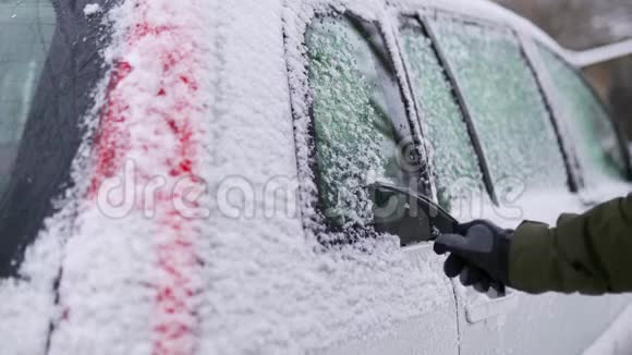 出行前用刮冰机清洗雪边车窗人从车窗上卸下冰男性视频的预览图
