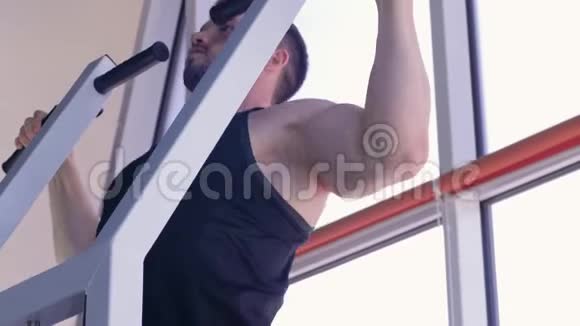 运动训练强壮的健美男子与美丽的运动身体拉在模拟器在力量锻炼在健身房视频的预览图