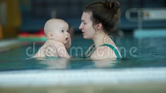 女人教他的小儿子在游泳池里潜水孩子有一张惊讶的脸加强免疫力发展视频的预览图