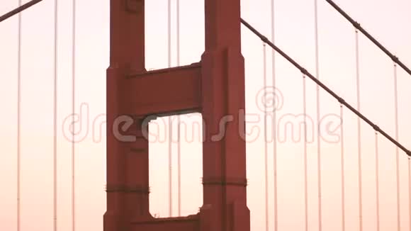 特写镜头倾斜在雄伟的日落金门大桥柱和汽车交通在旧金山加利福尼亚视频的预览图