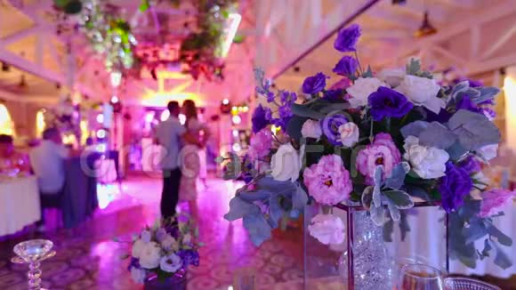 人们在婚礼上跳舞人们在花的背景上跳舞色彩鲜艳的婚礼派对视频的预览图