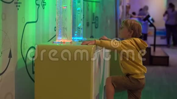 小男孩参观一个儿童科学博物馆他把气泡注入粘稠的液体视频的预览图