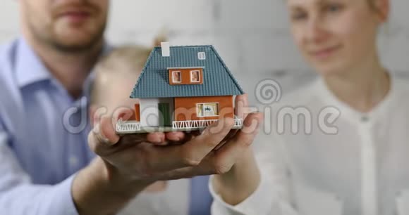 新家居理念拥有梦想房子规模模型的年轻家庭视频的预览图
