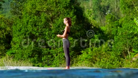 金发女孩在跑步时在瑜伽姿势中弯曲身体视频的预览图