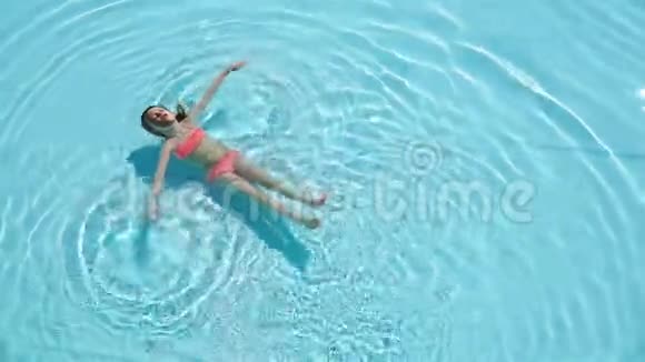 可爱快乐的小女孩喜欢在游泳池里游泳家庭暑假孩子在游泳池放松视频的预览图