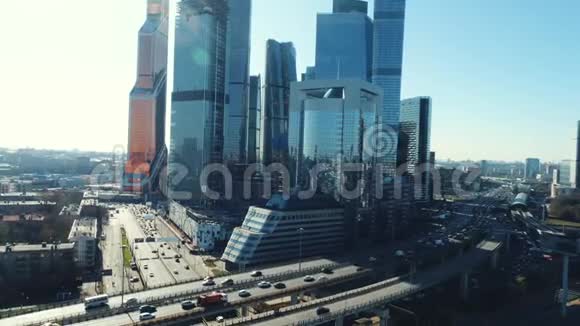在阳光明媚的夏日蓝色的背景下可以俯瞰高速公路和移动汽车以及莫斯科商务中心视频的预览图