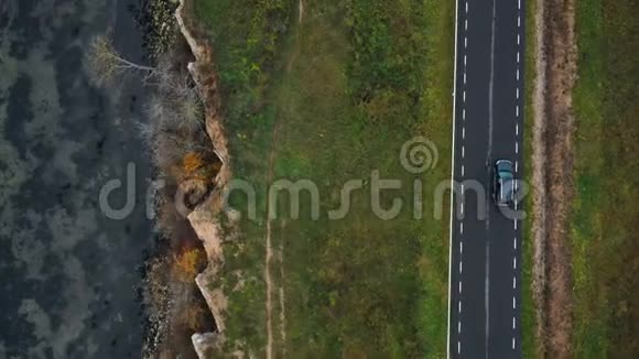 俯视无人机跟踪黑色汽车沿着秋湾路行驶非常接近美丽的侵蚀砂岩海岸视频的预览图