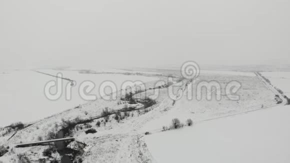 冬季景观从鸟瞰鸟瞰河床和草地乡村平稳向前飞视频的预览图