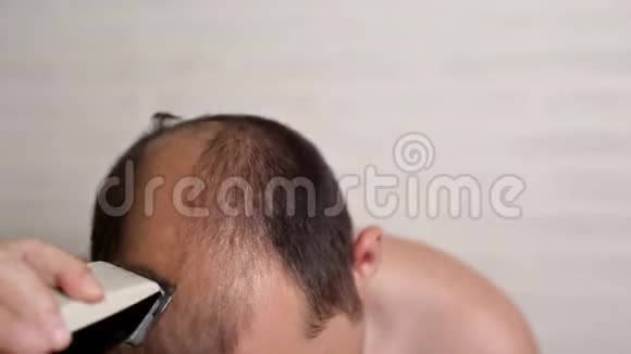 光头男在浴室里用电动剃须刀刮头发美容护理美容视频的预览图