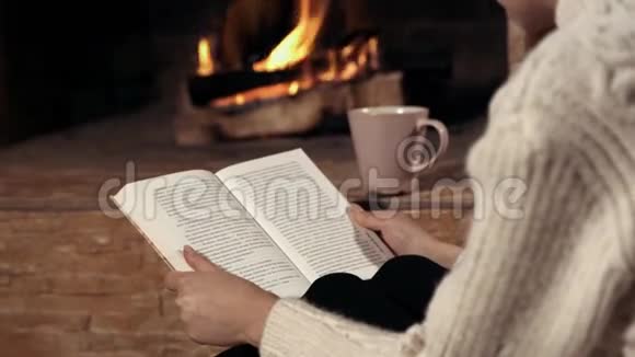 穿白色毛衣的女孩在壁炉旁看书视频的预览图