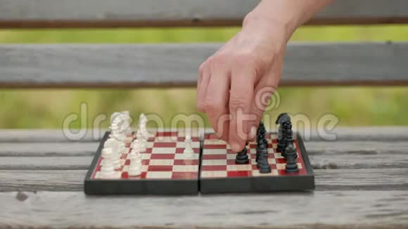 在户外下棋棋盘和数字在长凳上在绿色的背景下特写镜头视频的预览图