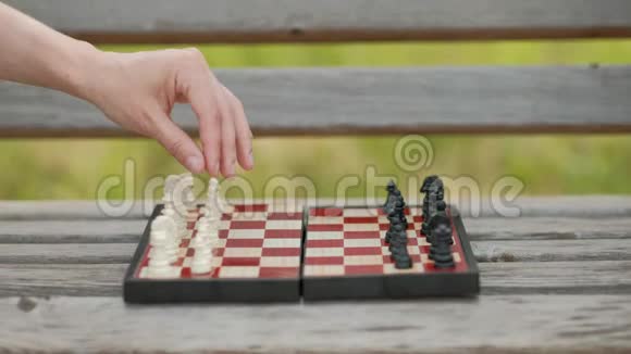 在户外下棋棋盘和数字在长凳上在绿色的背景下特写镜头视频的预览图