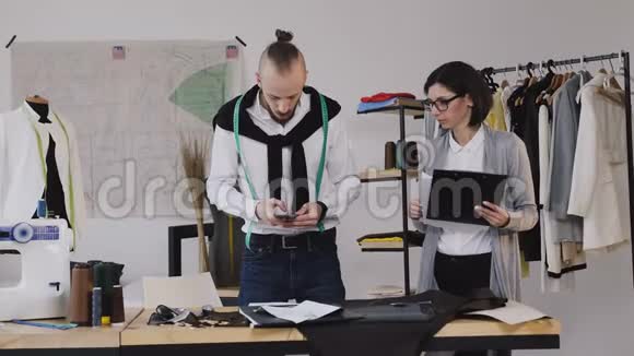 女孩的助手在纸上展示设计师的草图他工作室里的时装设计师视频的预览图