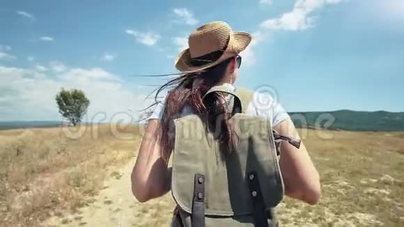 欧洲女性旅行者在徒步旅行生活方式之旅的干燥田野小径上背着背包视频的预览图