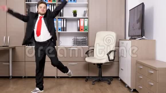 穿着正式西装的年轻商人在办公室里跳舞跳跳视频的预览图
