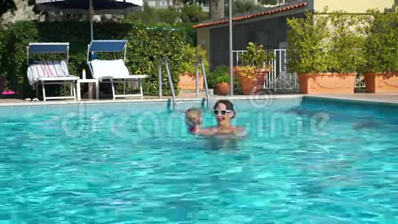 女人和她的女儿在泳池户外玩耍视频的预览图