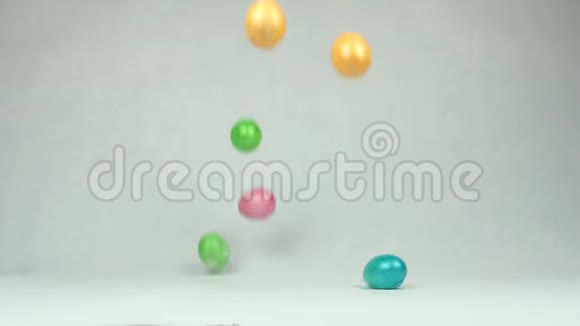 五颜六色的复活节彩蛋落在桌子上皮肤断裂白色背景是结束的概念视频的预览图