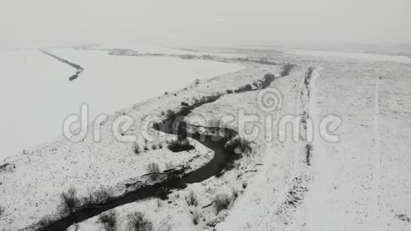 有河床和野生动物的冬季景观鸟瞰轻雪视频的预览图