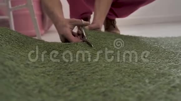 工作装饰工在地板上剪剪刀和办公室刀帆布人造草坪准备前夜的装饰品视频的预览图