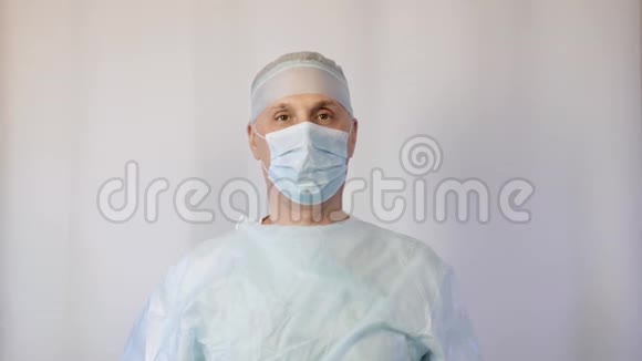一个戴着医用面罩的外科医生展示了一个手势停止必须停止视频的预览图