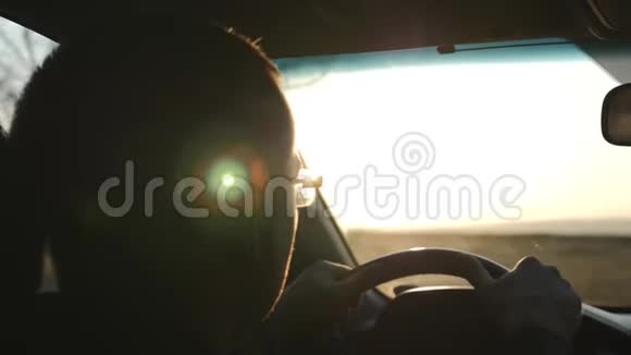 一个人在夕阳的照耀下骑着他的车后视镜的反光视频的预览图