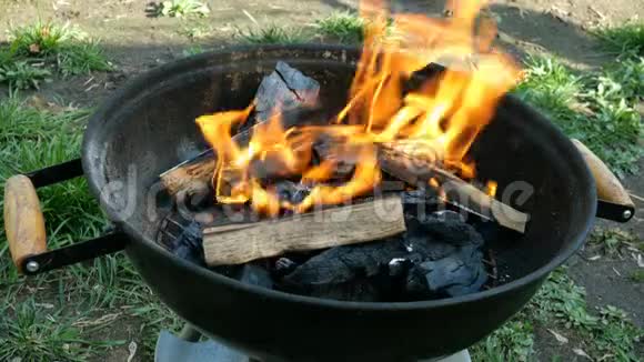 在篝火中明亮地燃烧着木柴和煤火焰在金属烤架或烧烤中燃烧视频的预览图