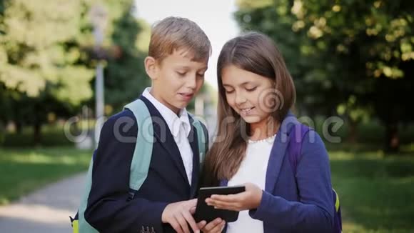 两名学童在户外使用平板电脑视频的预览图