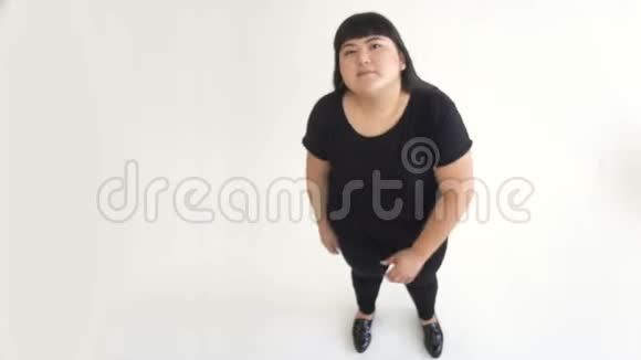 一位20岁情绪不愉快胖乎乎漂亮的亚洲女人在工作室的白色背景上的画像视频的预览图