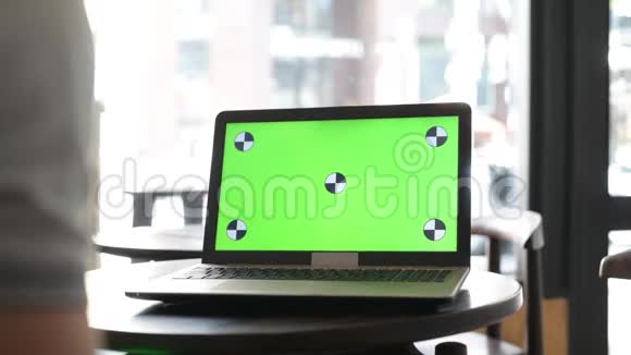 餐厅使用手机和带有绿色屏幕的笔记本电脑的人的特写视频的预览图