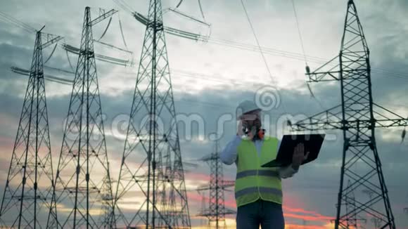 男工程师正在靠近电力线的地方打电话视频的预览图