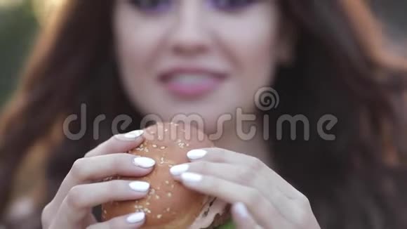 戴眼镜的时髦女孩吃美味的汉堡包视频的预览图
