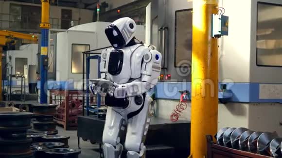 类似人类的机器人正在工厂里使用平板电脑视频的预览图