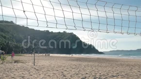 阳光明媚的一天潘慢动作在热带海滩上飞过排球网海岸和蓝天的背景视频的预览图