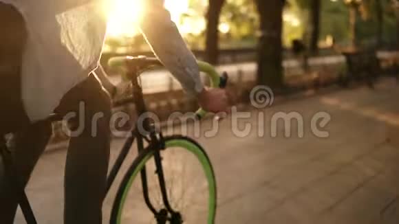 特写一个人在早晨公园或林荫大道骑自行车的镜头一个骑着徒步旅行的年轻人视频的预览图