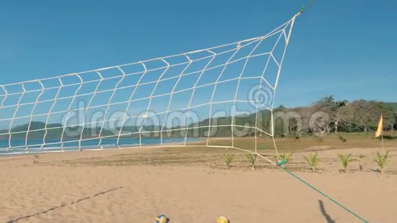 阳光明媚的一天潘慢动作在热带海滩上飞过排球网海岸和蓝天的背景视频的预览图