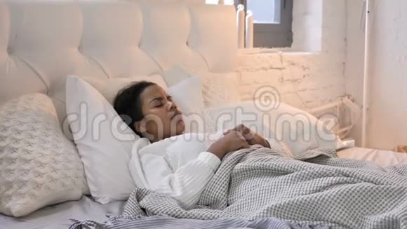 生病的非洲少女在床上咳嗽视频的预览图