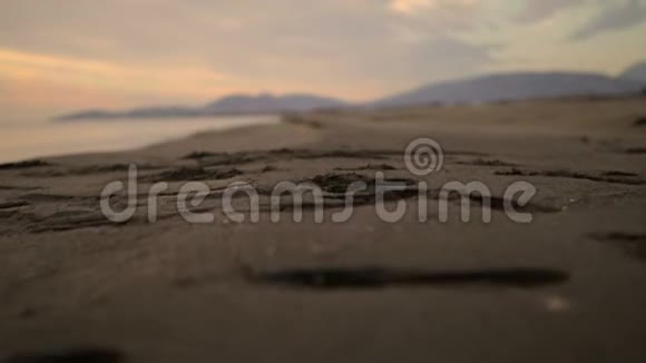 日落时湿沙上的脚印视频的预览图