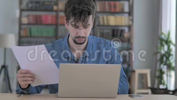 文书工作年轻人在笔记本电脑上打字和文件工作视频的预览图