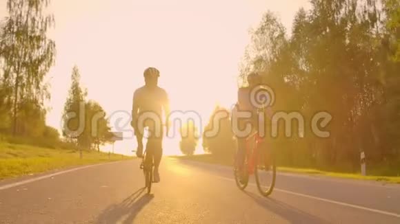 日落时分一男一女在高速公路上骑着运动自行车装备齐全戴着防护头盔动作缓慢时速120英里视频的预览图