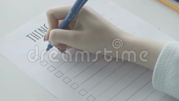 年轻女孩在笔记本上填写待办事项清单视频的预览图
