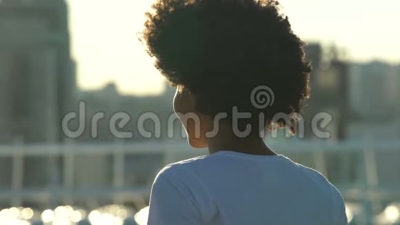 兴奋的非裔美国妇女享受户外朝阳欢乐后景视频的预览图
