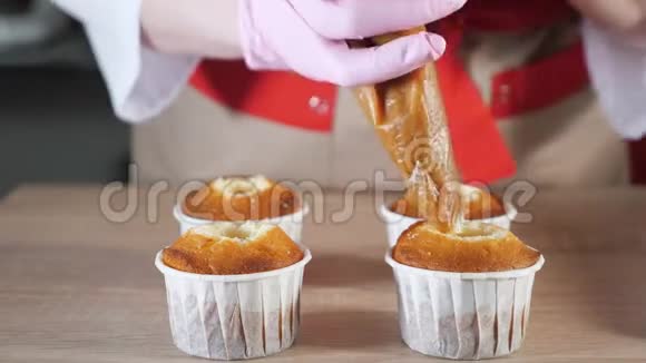 糕点厨师在纸杯中装满松饼焦糖馅再加上糕点袋视频的预览图