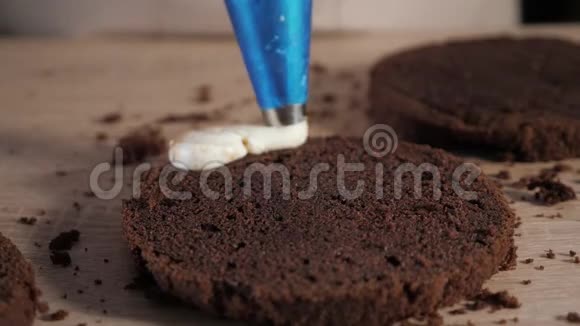 糕点厨师正在巧克力蛋糕上倒奶油和糕点袋在面包店做蛋糕视频的预览图