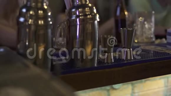 酒吧柜台上准备饮料的鸡尾酒摇瓶和烧杯关闭鸡尾酒酒吧用具摇床和视频的预览图