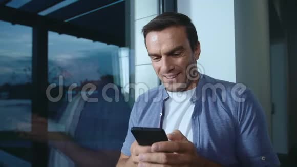 快乐的男人看手机帅哥在手机上看照片视频的预览图