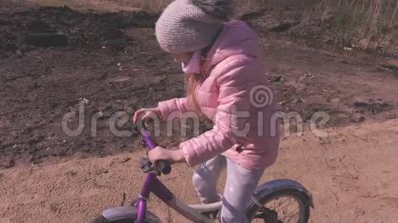 小女孩骑着自行车在公园的小路上视频的预览图