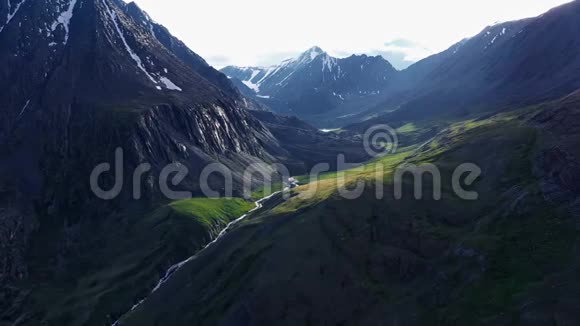 空中无人机景在日落柔和的光线下飞越松树林和山河背景山脉视频的预览图