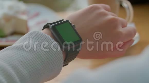 女人用他的智能手表应用程序女性在触摸屏上使用时尚的智能手表移动应用程序绿色屏幕视频的预览图